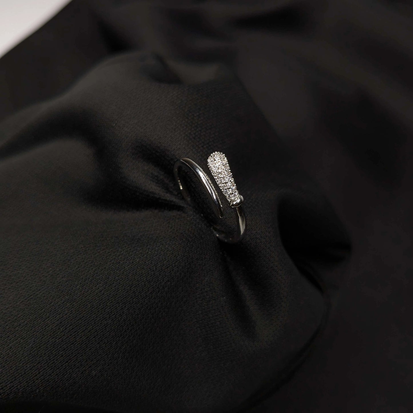 Silver ring with gemstones on a black fabric background