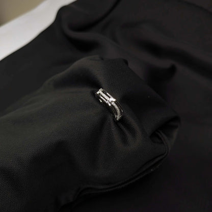 Close-up of a black fabric with a silver ring on a dark background